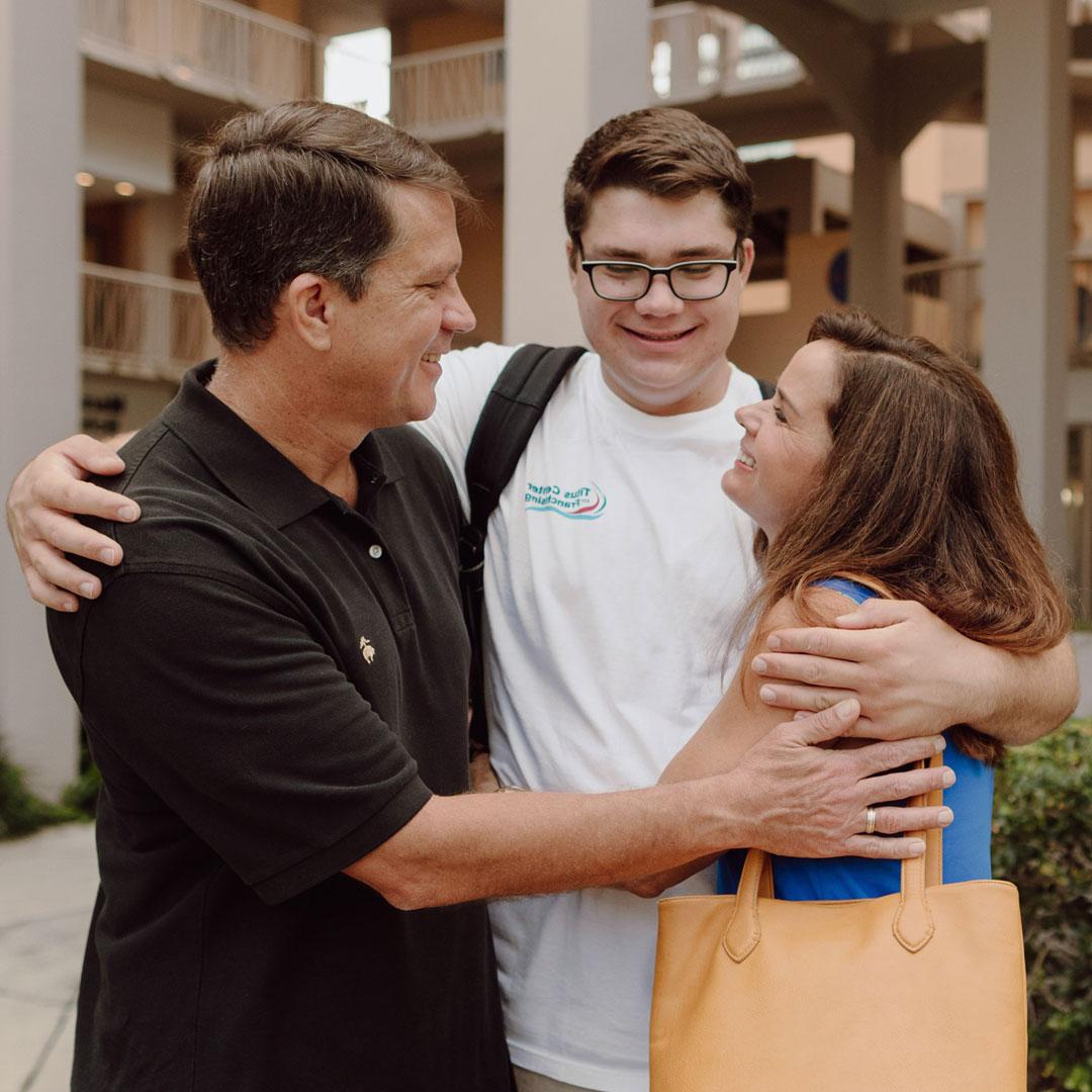 A mother and father hug their son as they drop him off at Palm Beach Atlantic University during Welcome Week.